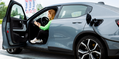Vrouw zit in haar elektrische auto tijdens het laden bij Tango electric