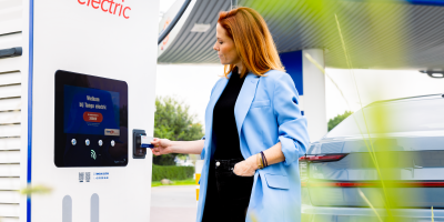 Vrouw scant Tango electric kaart aan laadstation